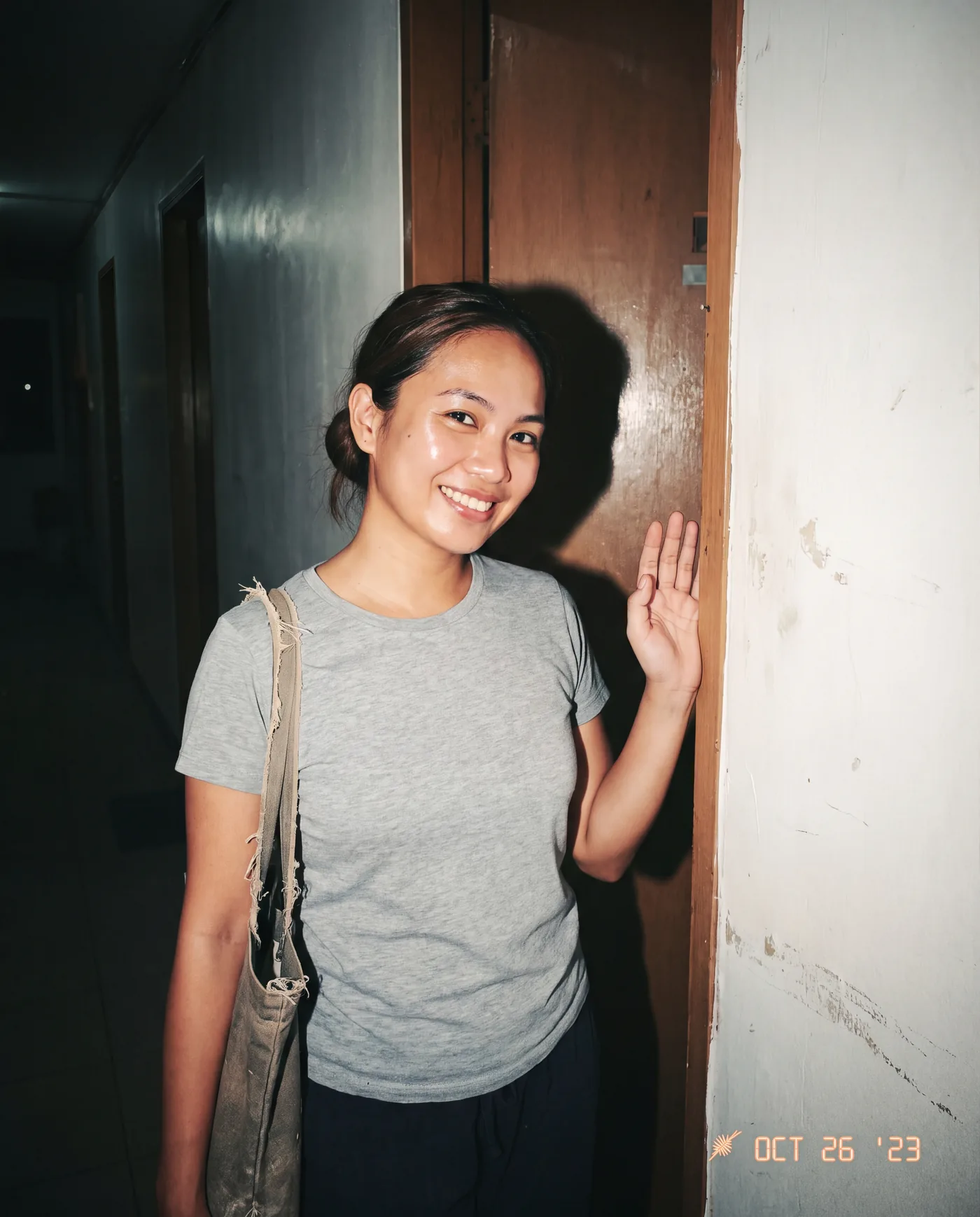 Plain-clothes nurse at a condo doorway with an unmarked kit bag. Discreet, no identifiable branding.